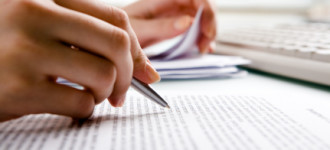 Close-up of secretarys hands doing paperwork